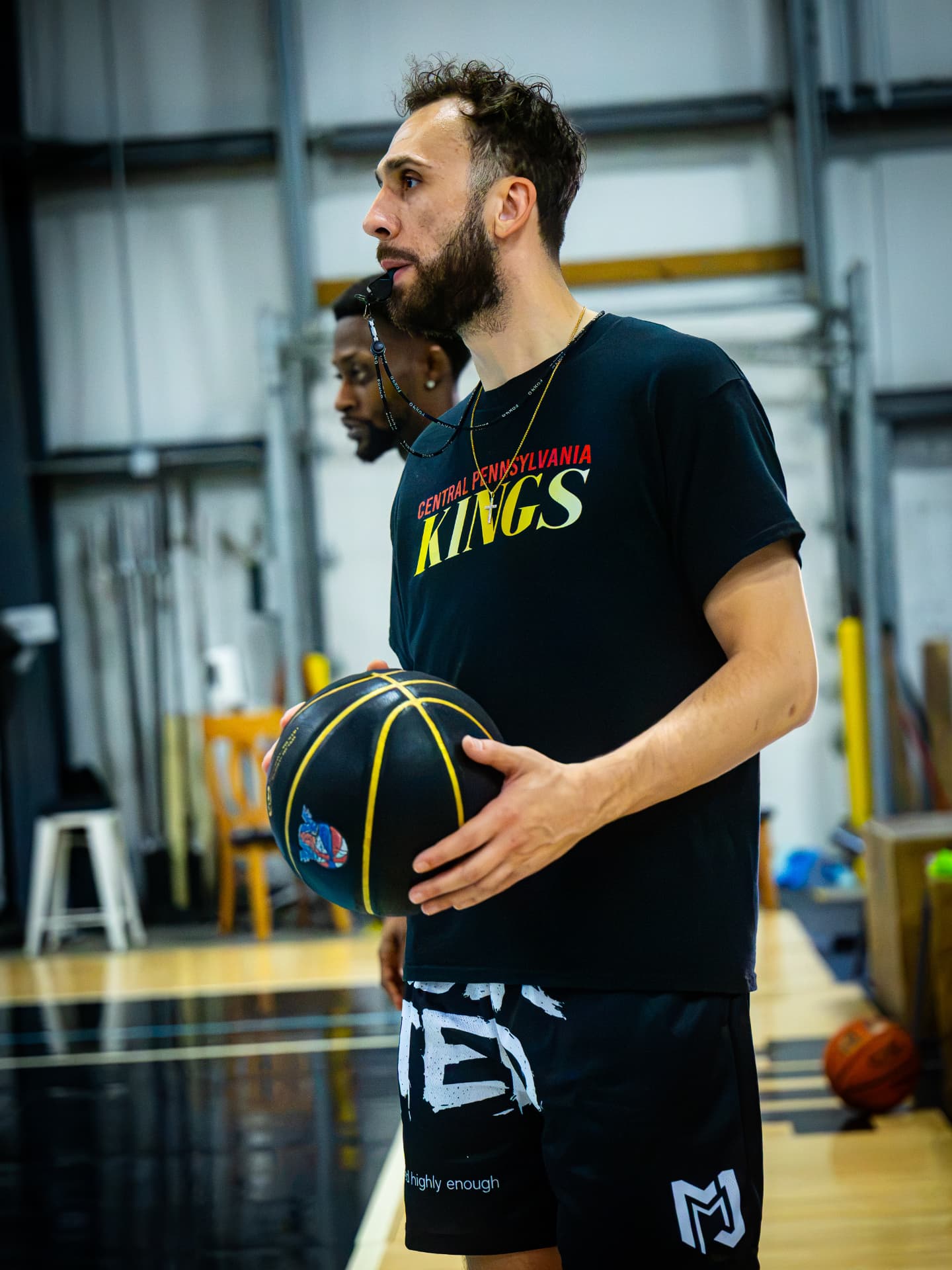 Coach holding a basketball during practice